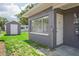 A gray home with a brick facade and lush backyard with a shed at 4512 S Lois Ave, Tampa, FL 33611