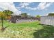 View of home's exterior from the backyard, showcasing a brick facade, green lawn, and a storage shed at 4512 S Lois Ave, Tampa, FL 33611