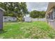 Large grassy backyard featuring a storage shed and partial fencing for privacy, with mature trees offering shade at 4512 S Lois Ave, Tampa, FL 33611