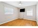 Cozy bedroom with hardwood floors, ceiling fan, and a mounted tv at 4512 S Lois Ave, Tampa, FL 33611