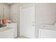 Bright laundry room with white machines, concrete walls and tile flooring at 4512 S Lois Ave, Tampa, FL 33611
