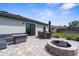 Backyard patio featuring a fire pit and outdoor seating area with mature landscaping at 4831 Hillman Ter, North Port, FL 34288