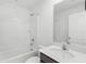 Bright bathroom featuring a shower-tub combo and a modern vanity with stone countertop at 4831 Hillman Ter, North Port, FL 34288
