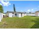 Spacious backyard with a lush lawn, privacy fence, and partial view of the home's exterior at 4925 Murray Hill Dr, Tampa, FL 33615