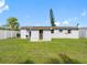 View of the home's backyard featuring a well-manicured lawn and white privacy fence at 4925 Murray Hill Dr, Tampa, FL 33615