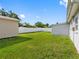 Large, grassy backyard bordered by white privacy fences and home exteriors at 4925 Murray Hill Dr, Tampa, FL 33615