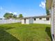 Spacious backyard featuring well-maintained lawn, partial fence, and exterior of the home at 4925 Murray Hill Dr, Tampa, FL 33615