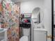 Small bathroom with floral shower curtain, oval mirror, and white toilet and vanity at 4925 Murray Hill Dr, Tampa, FL 33615