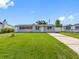 Charming single-story home with a well-manicured lawn and a long driveway under a bright sky at 4925 Murray Hill Dr, Tampa, FL 33615