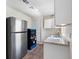 Galley kitchen with white cabinets, stainless steel refrigerator, and modern appliances at 4925 Murray Hill Dr, Tampa, FL 33615