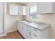 Well-lit kitchen featuring tile floors, stainless steel sink, and white cabinets offering storage at 4925 Murray Hill Dr, Tampa, FL 33615