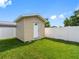 Storage shed with siding and a white door in a grassy backyard with a white privacy fence at 4925 Murray Hill Dr, Tampa, FL 33615
