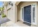 Charming front entrance with a stylish blue door, adjacent garage, and manicured landscaping at 501 Knights Run Ave # 6104, Tampa, FL 33602