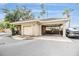 Detached garage with a carport featuring a neutral exterior, roll up garage door and manicured landscaping at 501 Knights Run Ave # 6104, Tampa, FL 33602