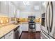 Bright kitchen featuring stainless steel appliances, granite countertops, mosaic backsplash and sleek white cabinetry at 501 Knights Run Ave # 6104, Tampa, FL 33602