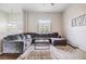 Bright living room features a large gray sectional sofa, decorative rug, and access to the dining area at 501 Knights Run Ave # 6104, Tampa, FL 33602