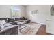 Cozy living room features a comfortable gray sectional sofa, decorative rug, and natural light at 501 Knights Run Ave # 6104, Tampa, FL 33602