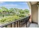 A covered patio with black metal railing overlooking a lush green landscape with mature trees and manicured shrubs at 501 Knights Run Ave # 6104, Tampa, FL 33602