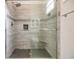 Shower features a tile surround with niche, gray tile floors, and a glass door at 501 Knights Run Ave # 6104, Tampa, FL 33602