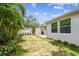 Lush backyard with tropical landscaping, a privacy fence, and a covered patio perfect for relaxing and entertaining at 527 Bay St, Dunedin, FL 34698