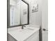 Bathroom vanity with a white countertop, modern faucet, and decorative mirror at 527 Bay St, Dunedin, FL 34698