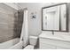 A bathroom is appointed with a shower-tub combo, a toilet, a vanity, and modern grey and white finishes at 527 Bay St, Dunedin, FL 34698