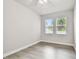 Inviting bedroom with neutral walls, wood-look floors, and bright windows offering verdant views at 527 Bay St, Dunedin, FL 34698