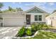 Charming home exterior with a well-manicured lawn, stone accents, and a convenient attached garage at 527 Bay St, Dunedin, FL 34698