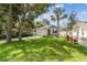 Charming home showcasing a manicured lawn, stone accents, and a welcoming two-car garage at 527 Bay St, Dunedin, FL 34698