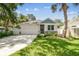 Charming home showcasing a manicured lawn, stone accents, and a welcoming two-car garage under blue skies at 527 Bay St, Dunedin, FL 34698