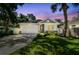 Charming home showcasing a manicured lawn, stone accents, and a welcoming two-car garage under colorful twilight skies at 527 Bay St, Dunedin, FL 34698