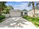 Charming home showcasing a manicured lawn, stone accents, and a welcoming two-car garage under blue skies at 527 Bay St, Dunedin, FL 34698