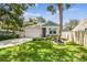 Charming home showcasing a manicured lawn, stone accents, and a welcoming two-car garage under blue skies at 527 Bay St, Dunedin, FL 34698