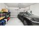 Spacious two-car garage with epoxy floor, storage shelving, and a sleek, dark SUV parked inside at 527 Bay St, Dunedin, FL 34698