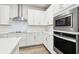 White kitchen featuring stainless steel appliances and ample counter space at 527 Bay St, Dunedin, FL 34698