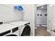Laundry room with modern washer and dryer units next to a hallway entrance at 527 Bay St, Dunedin, FL 34698