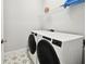 Laundry room with modern washer and dryer units and star patterned flooring at 527 Bay St, Dunedin, FL 34698