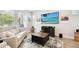 Inviting living room with modern furniture, a decorative rug, and a large screen television at 527 Bay St, Dunedin, FL 34698