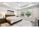Serene main bedroom featuring a tray ceiling, a large bed, and a calming beach-themed decor at 527 Bay St, Dunedin, FL 34698