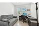 A functional office space with a sofa, desk, and natural light from the window offers a comfortable workspace at 527 Bay St, Dunedin, FL 34698