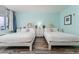 Bright bedroom featuring two twin beds, modern decor, and a serene, coastal ambiance at 611 Destiny Dr # 509, Ruskin, FL 33570