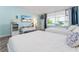 Bright main bedroom featuring two beds, TV, and water view from the window at 611 Destiny Dr # 509, Ruskin, FL 33570
