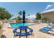 A beautiful in-ground pool sits near lounge chairs, tables, and tropical foliage at 611 Destiny Dr # 509, Ruskin, FL 33570
