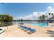 A beautiful in-ground pool is accompanied by lounge chairs and tropical foliage at 611 Destiny Dr # 509, Ruskin, FL 33570