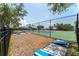 A fenced recreation area with a tennis court and a cornhole game setup at 611 Destiny Dr # 509, Ruskin, FL 33570