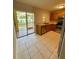 Kitchen features neutral tile, stainless appliances, wood cabinets, and sliding glass doors to a rear patio at 6333 Maisie Rd, Zephyrhills, FL 33542