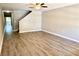 Bright living room boasts wood-look flooring, neutral walls, a staircase, and ample space for relaxing and entertaining at 6333 Maisie Rd, Zephyrhills, FL 33542