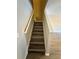 Staircase with wood-look steps and white railings connecting the levels of the home at 6333 Maisie Rd, Zephyrhills, FL 33542