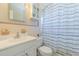 Clean bathroom featuring a vanity with sink, toilet, and a shower with a striped curtain at 6702 49Th N Ave, St Petersburg, FL 33709