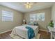 Serene bedroom with wood floors, a ceiling fan, two windows, and a comfortable bed with stylish decor at 6702 49Th N Ave, St Petersburg, FL 33709